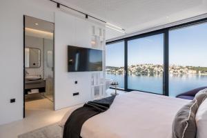 a bedroom with a large window with a view of the water at Villa Olive Vista 2, Zatoglav, Rogoznica in Podglavica