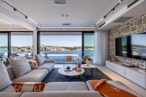 a living room with a couch and a tv at Villa Olive Vista 2, Zatoglav, Rogoznica in Podglavica