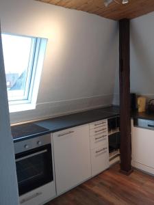 Una cocina con gabinetes blancos y una ventana. en Beautiful loft near city and Danube, en Neu-Ulm