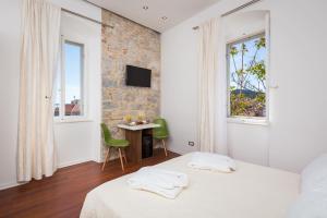 a bedroom with two beds and a table and window at Rooms Supreme Spalato in Split