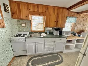 a kitchen with a white stove and a sink at SUNSET SHORES LIMIT 4 cottage in Gray