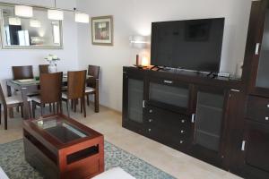 Una sala de estar con televisión y un comedor. en Apartamento Atalaya del Mar, en Mijas Costa