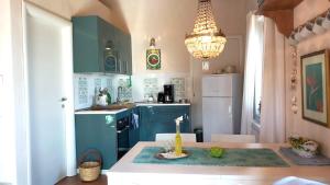 カステルモーラにあるCasa Lucarellaのキッチン(青いキャビネット、キャンドル付)