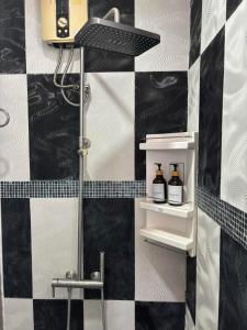 a bathroom with a black and white checkered wall at Spacious and cozy Thai House in Ban Bang Khu