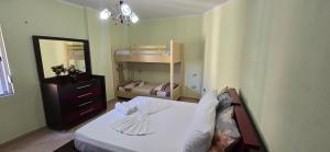 ヴロラにあるApartment me qera Lungomare Vlore Dejvid by the seaのドレッサーと鏡付きのベッドのある寝室
