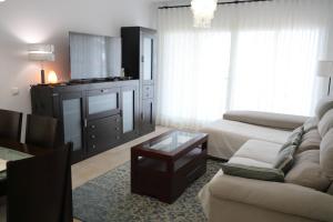 Una sala de estar con un sofá y una mesa de café. en Apartamento Atalaya del Mar, en Mijas Costa