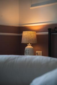 a lamp sitting on top of a bed at Locanda Gaudemus Boutique Hotel in Sistiana