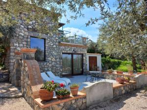 a stone house with a patio and a deck at Torre Cangiani in Massa Lubrense