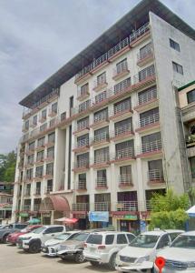 a large building with cars parked in a parking lot at 3BR Across Burnham Park Baguio Transient - Unit 23 in Baguio