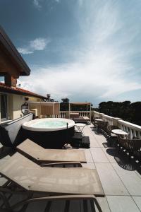 a patio with a pool and tables and chairs at Locanda Gaudemus Boutique Hotel in Sistiana