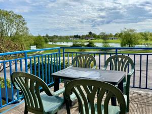 a table and chairs on a balcony with a view of a river at La Terrasse vue étangs, Babyfoot, jeux de société by BookingFuté in Socourt