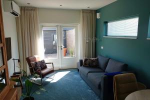 ein Wohnzimmer mit Sofa und Fenster in der Unterkunft African Tree in Terwolde