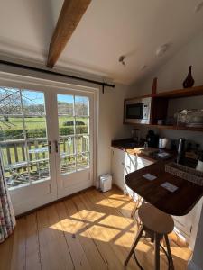 a kitchen with a table and a door to a balcony at The Parcel Shed Gilling East in Gilling East +16 photos