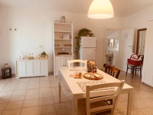 a kitchen with a table and chairs and a refrigerator at Case Vacanze - da Francesco in Policoro