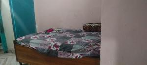 a bedroom with a bed with a quilt on it at Aruntyagi in Khekra