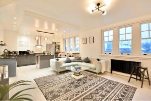 a living room with a couch and a table at 3 x Bedroom Riverside Flat with HOT TUB on Roof Terrace in London