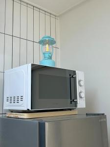 a microwave with a blue vase on top of it at Momo House in Gimhae