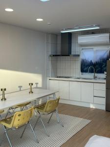 a kitchen with a table and yellow chairs at Momo House in Gimhae
