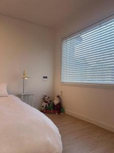 a bedroom with a bed and a large window at Momo House in Gimhae