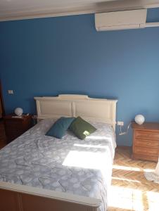 a bedroom with a bed with a blue wall at La casa di nonna Mary in Diano Castello +5 photos