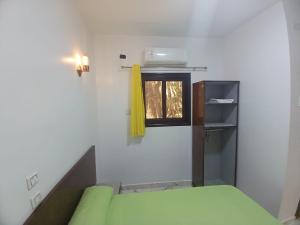 een kamer met een groene bank en een raam bij Esmerada in Aswan