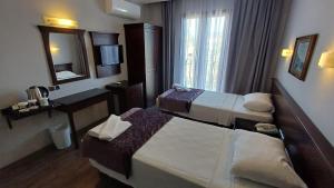 a hotel room with two beds and a mirror at Club Viva Hotel in Marmaris +21 photos