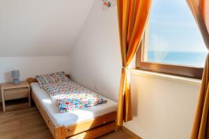 a small bed in a room with a window at Domki ALEX - Nad zatoką - Piękne Widoki Cisza i Spokój in Swarzewo
