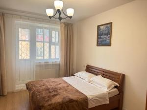 a bedroom with a bed and a window at TP Central Comfort, 2 Bedroom Apartment in Ulaanbaatar +6 photos