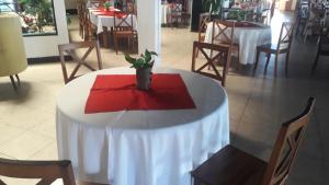 a white table with a red napkin and a plant on it at Vatolahy in Antsirabe