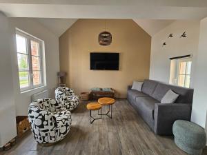 a living room with a couch and two chairs at Cottage Salomé in Rue
