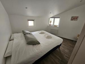 a bedroom with a large white bed with two pillows at Cottage Salomé in Rue