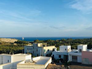 a group of white buildings with the ocean in the background at Depandance Maria con terrazza in Marittima