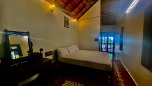 una piccola camera da letto con un letto e uno specchio di Udupi Heritage a Udupi