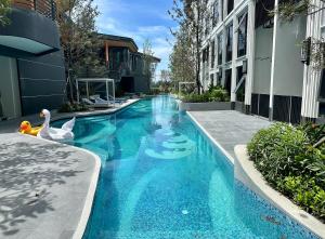 a swimming pool with two swans in a building at Bellevue lagoon 20 units in Laguna Phuket