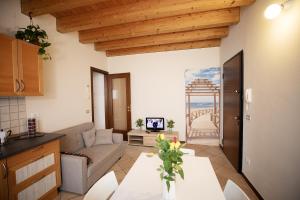 una cucina e un soggiorno con un tavolo e un divano di Salix Home a Lazise