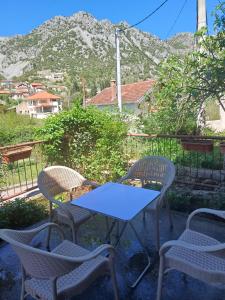 a blue table and chairs with a mountain in the background at Apartman Čerkez in Stolac