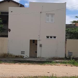 a white house with a dog sitting in front of it at Kitipê Arretado da Peste in Aquiraz