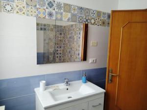 a bathroom with a sink and a mirror at Rooms Guest House Il Porto Vecchio in Stintino +25 photos