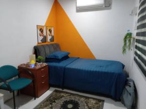 a bedroom with a bed and a desk and a chair at KAMI roomstay 2 in Kampong Banggol Lalang