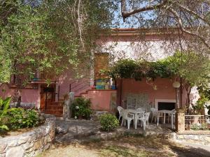 a house with a table and chairs in front of it at B&B IL VECCHIO GELSO in Palinuro