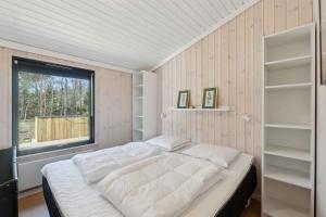 a bedroom with a large bed and a window at Cozy Summer House In North Jutland in Jerup