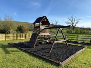 a playground with a slide in a yard at Ribble Valley Hideaways in Preston