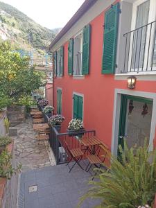 a patio with chairs and a building with green shutters at Le Camere Di Paolo in Riomaggiore +25 photos