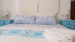 1 dormitorio con 1 cama con 2 mesitas de noche azules en B&B Guest House Il Porto Vecchio, en Stintino
