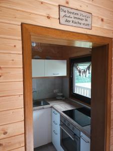 a kitchen in a tiny house with a window at Weiherhüttla in Untersteinach +12 photos