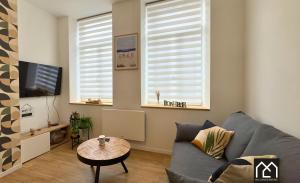 a living room with a couch and a table at Ro'Cam Spot - Hyper Centre, Cour, parking in Boulogne-sur-Mer