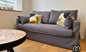 a gray couch with pillows in a living room at Ro'Cam Spot - Hyper Centre, Cour, parking in Boulogne-sur-Mer +19 photos