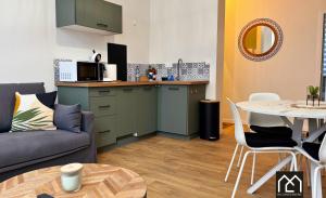 a kitchen and a living room with a couch and a table at Ro'Cam Spot - Hyper Centre, Cour, parking in Boulogne-sur-Mer