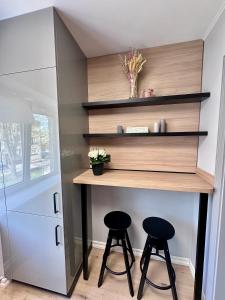 a small kitchen with two stools under a counter at Aesthetic in Ludza +2 photos