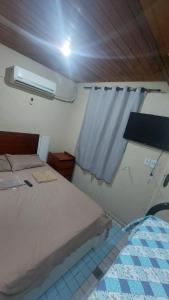 リオデジャネイロにあるHostel Bom e Familiarのベッドと窓のある小さな部屋